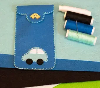 Bild einer selbstgemachten Schutztasche für Smartphones zusammen mit Nadel und Faden.