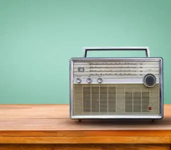 Graues Vintage-Radio steht auf hölzernem Untergrund.