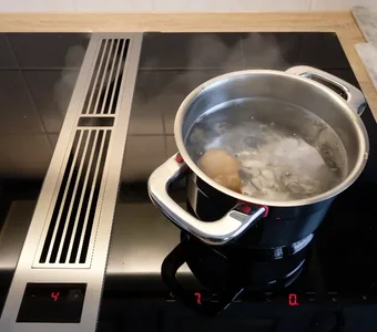 Ein Kochtopf befindet sich mit kochendem Wasser und Eiern auf einem Induktionsherd