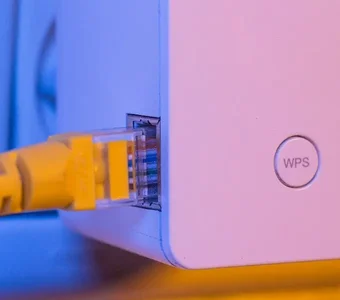 Weißer WLAN Verstärker mit gelbem LAN-Kabel