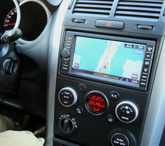Blick auf Autoinnenraum mit Lenkrad sowie Armaturenbrett mit Autoradio und Navigationsgerät