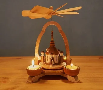 Tischpyramide mit einer Plattform auf der eine kleine Kapelle  steht und die von vier Teelichtern in Bewegung gesetzt wird