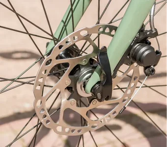 Nahaufnahme eines Scheibenbremssystems an einem Rennrad mit grünem Rahmen