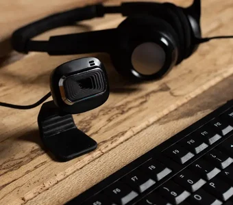 Webcam und Headset mit Tastatur auf Schreibtisch