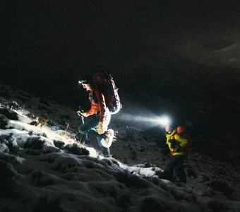 Zwei Personen steigen einen Berg mit Schnee hinauf