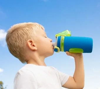 Junge trinkt aus blau-grüner Trinkflasche