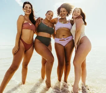 Vier Frauen mit cooler Beachwear stehen im Wasser