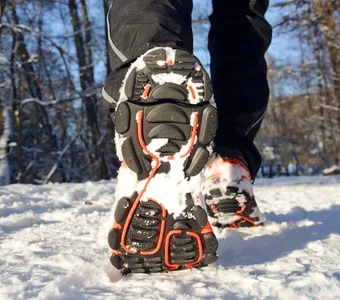 Nahaufnahme von Laufschuhen mit stark profilierter Sohle im Schnee