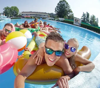 Gruppe von Freunden auf Luftmatratzen in einem Pool