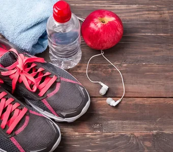 Die perfekten Laufaccessoires: Handtuch, Wasser, Kopfhörer, ein Apfel und ein paar Laufschuhe