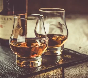 Zwei Gläser Whisky stehen auf einem Tisch