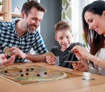 Junge spielt ein Brettspiel mit den Eltern