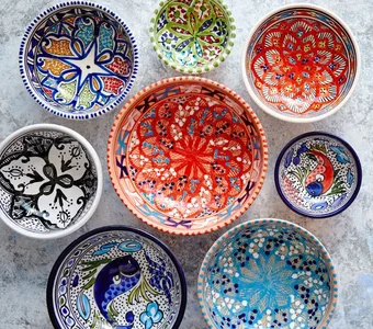 Mehrere vielfarbige Teller im marokkanischen Design vor grauem Marmor
