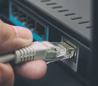 Ein LAN Kabel wird in den LAN Port eines Routers gesteckt