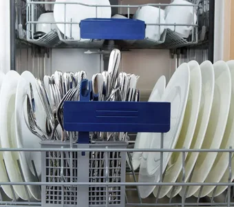 Spülmaschine ist voll beladen mit sauberem Geschirr und Besteck
