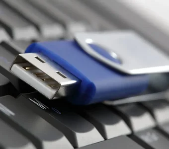 Der USB Typ A Anschluss eines USB Sticks wird auf einer Tastatur gezeigt