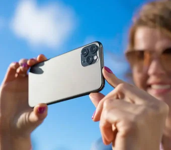 Frau testet die neue Kamera des Apple iPhone bei Sonnenschein aus