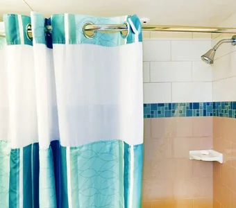 Duschvorhang aus gemischtem Material vor eine Dusche, der sich in der Farbe unterscheidet