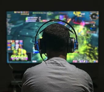 Mann trägt Headset beim Computerspielen