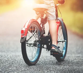 Ein Kind fährt mit seinem Fahrrad auf einem asphaltierten Weg