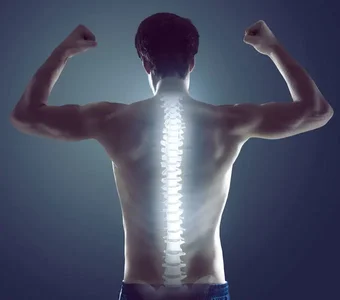 Mann mit Rücken zur Kamera und angespannten Muskeln, dessen Wirbelsäule grafisch hervorgehoben ist