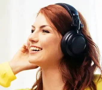 Junge Frau genießt den Klang ihrer Bluetooth-Kopfhörer