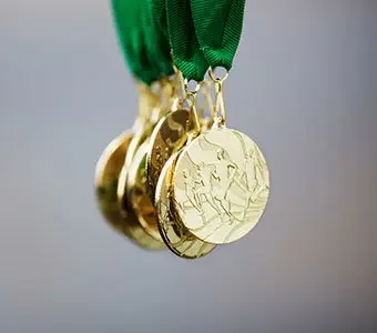Nahaufnahme von sieben Goldmedaillen