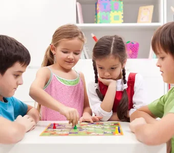 Vier Kinder spielen ein Gesellschaftsspiel