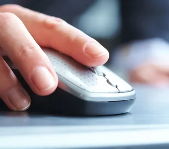 Eine weibliche Hand steuert ihren PC mit einer Maus