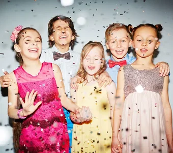 Festlich gekleidete Kinder im Konfetti-Regen