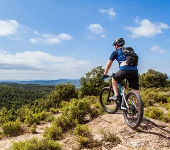 Ein Mann auf einem Mountainbike genießt die Landschaft von einem Berg aus