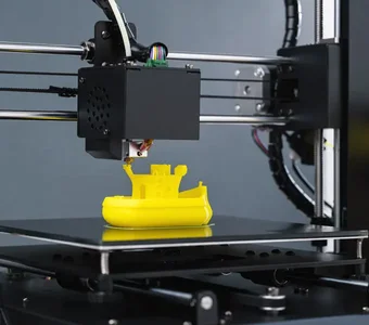 Nahaufnahme eines gelben Spielzeugbootes, welches durch einen 3D-Drucker hergestellt wird