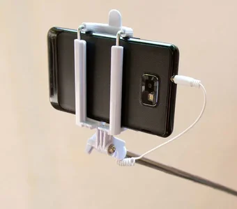 Smartphone mit Kabelverbindung zum Selfiestick gekoppelt