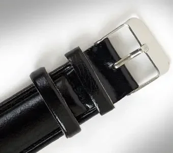 Nahaufnahme eines klassisch-schwarzen Lederarmbandes einer Armbanduhr vor neutralem Hintergrund.