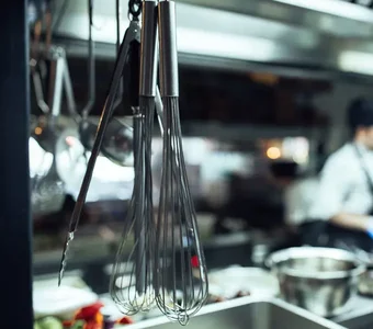 Quirle aus Edelstahl hängen in der Restaurantküche