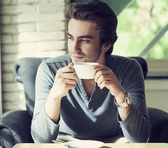 Ein Mann trinkt eine Tasse in einem Café