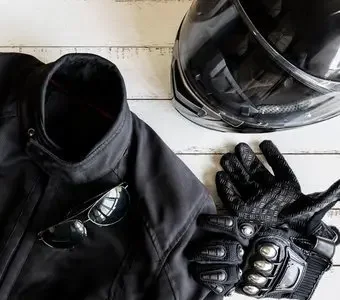 Schwarze Motorradschutzkleidung mit Helm, Handschuhen und Zündschlüssel