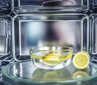 Schale mit Wasser und Zitronenscheiben in einer Mikrowelle
