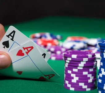 Pokerchips und zwei Asse in einer Hand