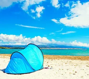 Blaue Pop-up-Strandmuschel am Strand - Im Hintergrund weite Landschaften
