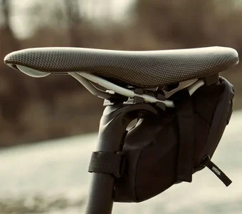 Unter dem Sattel eines Fahrrads befindet sich eine kleine schwarze Tasche an der Sattelstütze