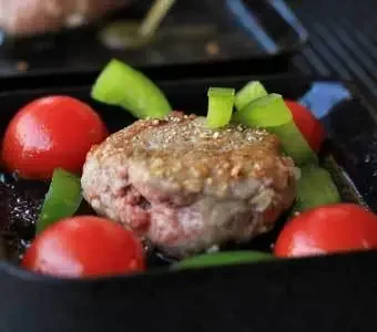 Gemüse und Fleisch werden auf einem Raclette Gerät gegrillt.