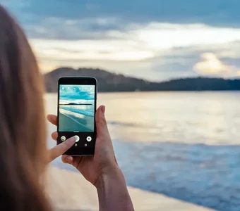 Eine Frau schießt ein Landschaftsbild mit ihrem Smartphone