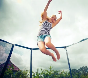 Ein Mädchen springt auf einem Trampolin hoch