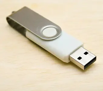 Silber-weißer USB-Stick auf hellem Holz-Untergrund