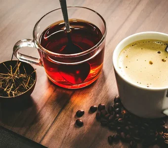 Eine Tasse Tee und eine Tasse Kaffee auf einer Holzplatte