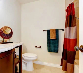 Badezimmer mit Textil-Duschvorhang mit verschiedenen Farbstreifen