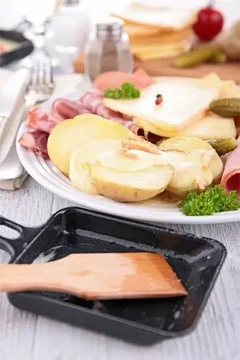 Aufnahme von einem Raclette-Pfännchen und passenden Zutaten
