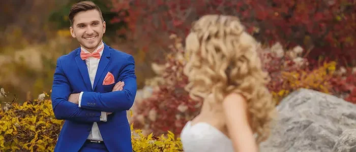 Bräutigam im blauen Sakko lacht seine Braut an