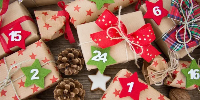 Aufnahme mehrerer Päckchen in weihnachtlichem Geschenkpapier, die zusätzlich weihnachtlich dekoriert sind